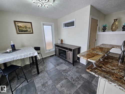 Dining room featuring a textured ceiling and stone tile flooring - 8512 131 Avenue, Edmonton, AB - Indoor