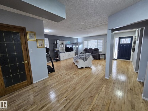 Living area featuring light wood-style flooring and a textured ceiling - 8512 131 Avenue, Edmonton, AB - Indoor