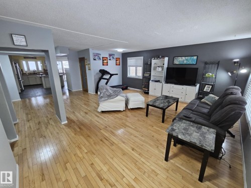 Living area with light wood-style flooring and a textured ceiling - 8512 131 Avenue, Edmonton, AB - Indoor