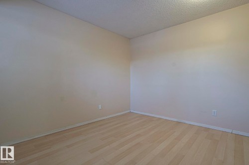 Unfurnished room featuring light wood-style flooring and a textured ceiling - 1526 69 Street Nw, Edmonton, AB - Indoor Photo Showing Other Room
