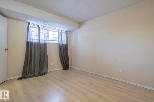 Unfurnished room with light wood finished floors and a textured ceiling - 1526 69 Street Nw, Edmonton, AB - Indoor Photo Showing Other Room