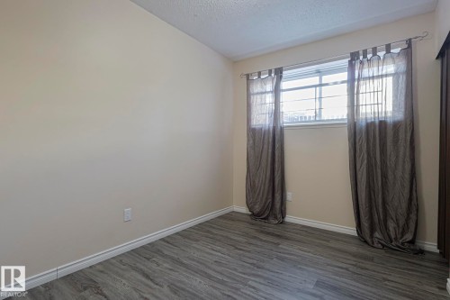 Empty room with baseboards and dark wood-style flooring - 1526 69 Street Nw, Edmonton, AB - Indoor Photo Showing Other Room