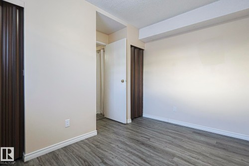 Unfurnished bedroom featuring a textured ceiling and dark wood finished floors - 1526 69 Street Nw, Edmonton, AB - Indoor Photo Showing Other Room
