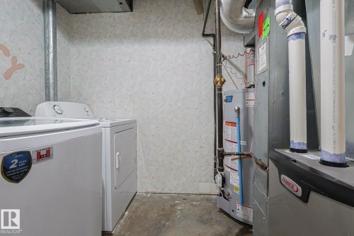 Laundry area featuring heating unit, water heater, and washing machine and clothes dryer - 1526 69 Street Nw, Edmonton, AB - Indoor
