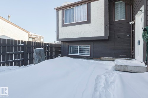 Snow covered rear of property with stucco siding - 1526 69 Street Nw, Edmonton, AB - Outdoor With Exterior