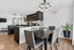 Dining room featuring light wood-style floors and hanging lights - 