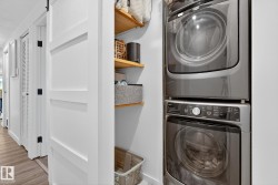 Laundry area featuring stacked washer / dryer and light wood-type flooring - 