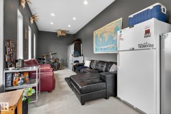 Living room with unfinished concrete floors, a heating unit, and a garage - 