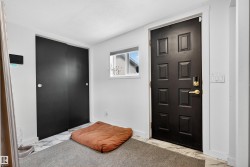 Foyer entrance featuring marble look tiles and a textured ceiling - 