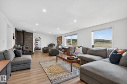 Living area with a wood stove, light wood-type flooring, and recessed lighting - 