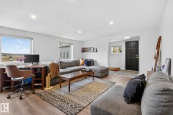 Living area featuring light wood-style flooring, recessed lighting, a desk, and lofted ceiling - 