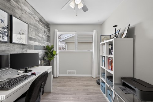 Office space featuring an accent wall, light wood finished floors, wood walls, and ceiling fan - 7719 71 Avenue, Edmonton, AB - Indoor Photo Showing Office