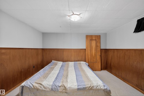 Bedroom featuring carpet flooring, wooden walls, and wainscoting - 7719 71 Avenue, Edmonton, AB - Indoor Photo Showing Bedroom