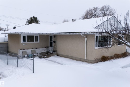 Snow covered property featuring stucco siding - 7719 71 Avenue, Edmonton, AB - Outdoor With Exterior