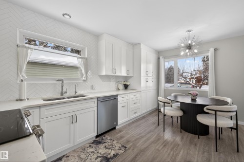 Kitchen featuring white cabinets, dishwasher, dark wood finished floors, and light stone counters - 7719 71 Avenue, Edmonton, AB - Indoor