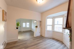 Unfurnished room featuring arched walkways and light wood finished floors - 