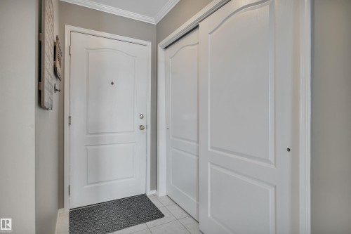 Doorway to outside featuring tile patterned floors and crown molding - 203 35 Sir Winston Churchill Avenue, St. Albert, AB - Indoor Photo Showing Other Room