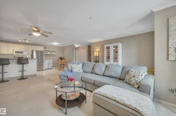 Living room with ornamental molding, ceiling fan, and light carpet - 