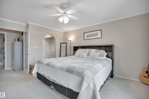 Carpeted bedroom featuring crown molding, ceiling fan, and a closet - 203 35 Sir Winston Churchill Avenue, St. Albert, AB - Indoor Photo Showing Bedroom