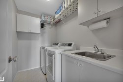 Laundry room featuring cabinet space, washer and clothes dryer, and light floors - 