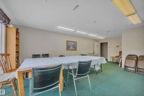 Carpeted dining area with a textured ceiling - 203 35 Sir Winston Churchill Avenue, St. Albert, AB - Indoor Photo Showing Dining Room