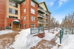 Snow covered property featuring a view of apartment building / complex - 