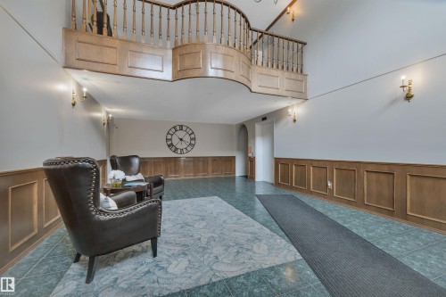 Sitting room featuring wainscoting, a high ceiling, arched walkways, and a decorative wall - 203 35 Sir Winston Churchill Avenue, St. Albert, AB - Indoor Photo Showing Other Room