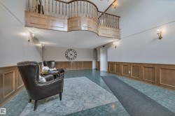 Sitting room featuring wainscoting, a high ceiling, arched walkways, and a decorative wall - 