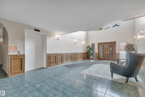 Common area with a wainscoted wall, a decorative wall, and a textured ceiling - 203 35 Sir Winston Churchill Avenue, St. Albert, AB - Indoor Photo Showing Other Room