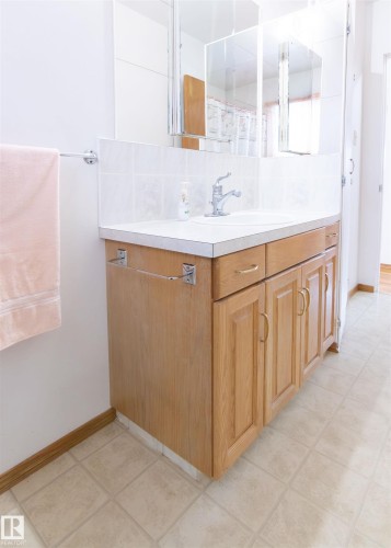 Full bath featuring decorative backsplash, vanity, light tile patterned flooring, and a shower with curtain - 9305 151 Street, Edmonton, AB - Indoor Photo Showing Bathroom