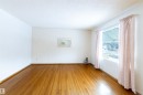 Living room with light wood-style flooring and a textured ceiling - 9305 151 Street, Edmonton, AB  - Indoor Photo Showing Other Room 