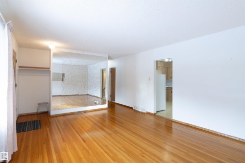 Living room with light wood finished floors and baseboards - 9305 151 Street, Edmonton, AB - Indoor Photo Showing Other Room