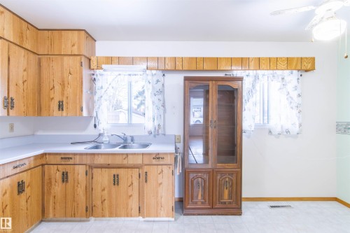 Kitchen featuring light countertops, healthy amount of natural light, and a ceiling fan - 9305 151 Street, Edmonton, AB - Indoor Photo Showing Kitchen With Double Sink