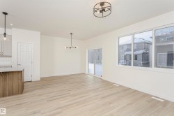 Unfurnished dining area featuring light wood-type flooring and hanging lights - 