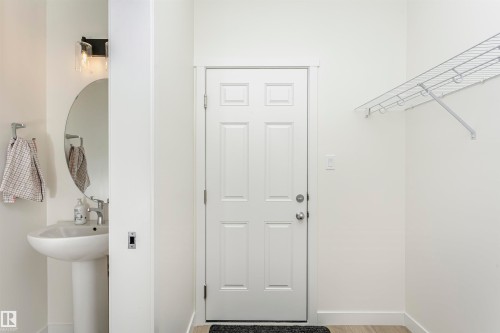 Laundry area with baseboards and light wood-type flooring - 5111 Kinney Way Sw, Edmonton, AB - Indoor
