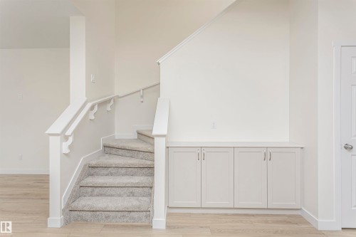 Staircase featuring wood finished floors and baseboards - 5111 Kinney Way Sw, Edmonton, AB - Indoor Photo Showing Other Room