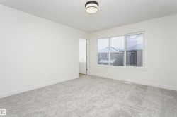 Unfurnished room with baseboards and light colored carpet - 