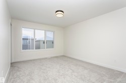 Unfurnished room featuring light carpet and baseboards - 