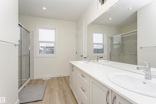 Bathroom featuring double vanity, healthy amount of natural light, a shower stall, light wood-style floors, and recessed lighting - 5111 Kinney Way Sw, Edmonton, AB - Indoor Photo Showing Bathroom