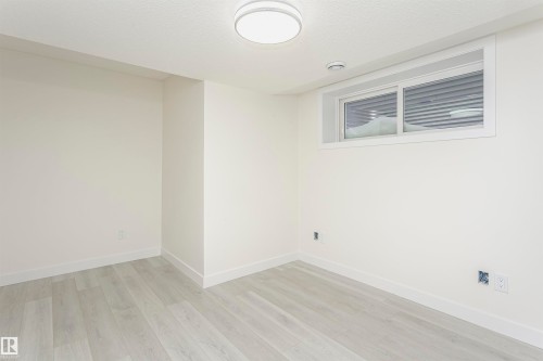 Unfurnished room with light wood finished floors and a textured ceiling - 5111 Kinney Way Sw, Edmonton, AB - Indoor Photo Showing Other Room