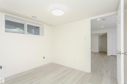 Empty room with light wood finished floors and recessed lighting - 