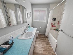 Full bathroom featuring vanity, dark wood-type flooring, and shower / bathtub combination with curtain - 
