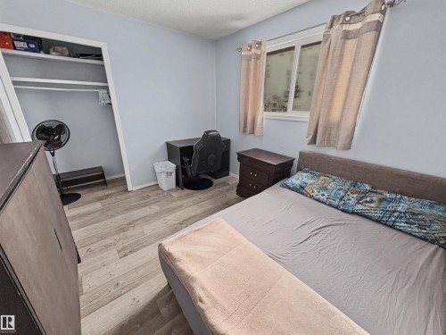 Bedroom with light wood-style floors, a textured ceiling, and a closet - 4602 42 Avenue, Bonnyville Town, AB - Indoor Photo Showing Bedroom