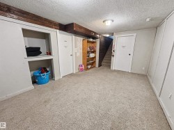Finished basement with a textured ceiling and light carpet - 