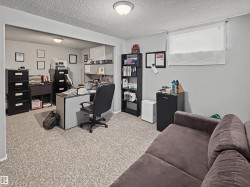 Office area with a textured ceiling and light carpet - 