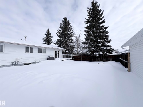 Snowy yard with a fenced backyard and french doors - 4602 42 Avenue, Bonnyville Town, AB - Outdoor