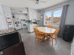 Dining area featuring finished concrete flooring, a textured ceiling, and ceiling fan - 