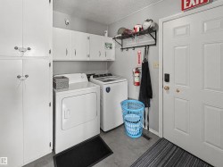 Laundry area featuring a textured ceiling, cabinet space, and washing machine and dryer - 