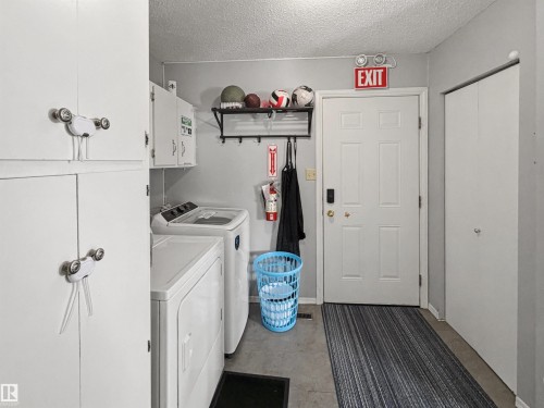 Laundry room featuring a textured ceiling, washer and clothes dryer, and cabinet space - 4602 42 Avenue, Bonnyville Town, AB - Indoor Photo Showing Laundry Room
