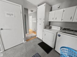 Laundry room with a textured ceiling, washing machine and clothes dryer, and cabinet space - 